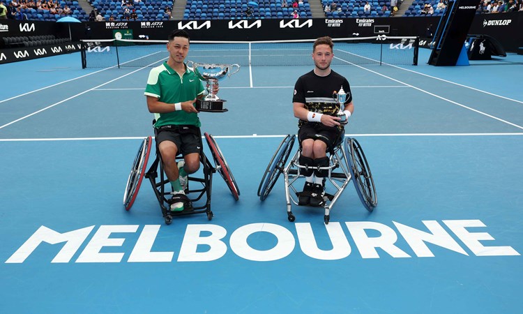 Tokito Oda and Alfie Hewett sat holding their trophies on court at the Australian Open