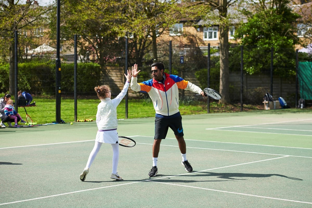 Two players high fiving at a Free Park Tennis session