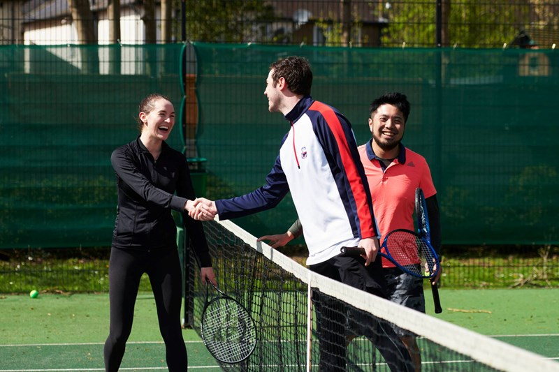 Local Tennis Leagues players shaking hands at the net