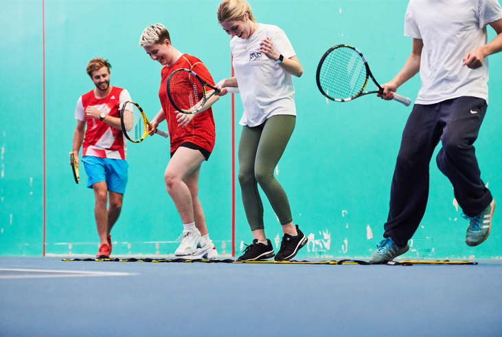 People on tennis court smiling 